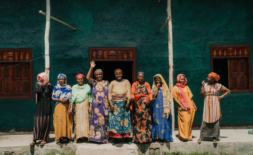 Ababech stands outside her home with women from her village in Ethiopia that now has clean water through neverthirst